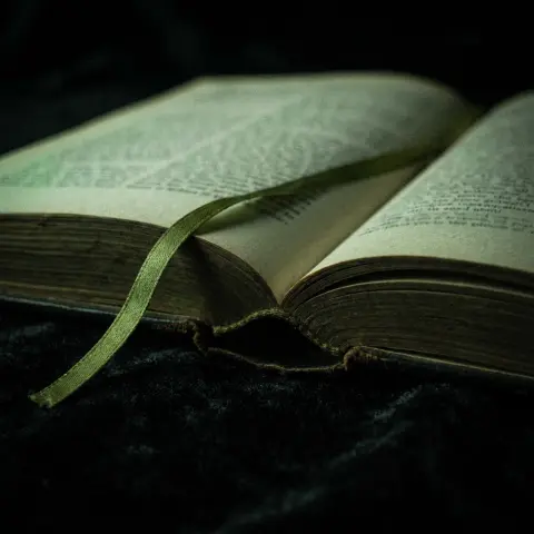 An open book with a green ribbon marker